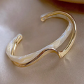 Elegant åben armbånd lavet af hvid emalje og guld