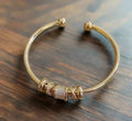 Justerbar armbånd med gyldne charms